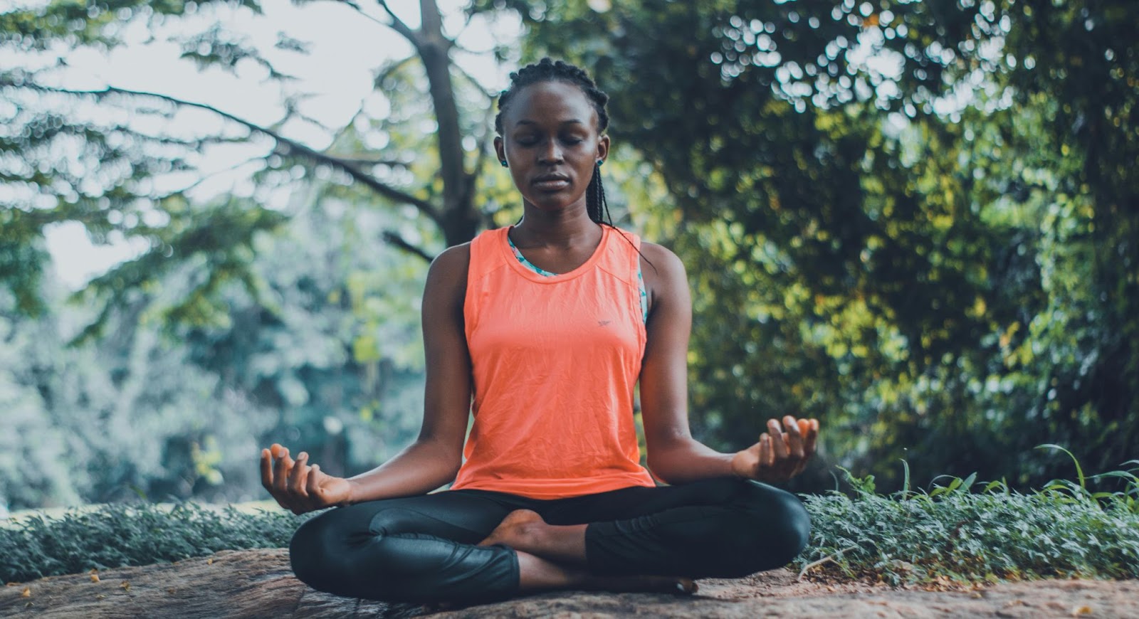 Woman meditating in nature during dopamine fasting, representing mindfulness and resetting the brain’s reward system.