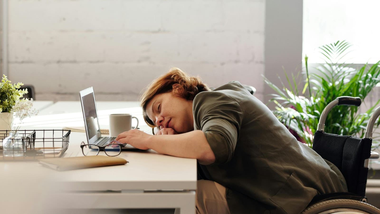Woman fell asleep at her desk while working, highlighting the impact of poor rest on focus and the need for a strong deep sleep routine.