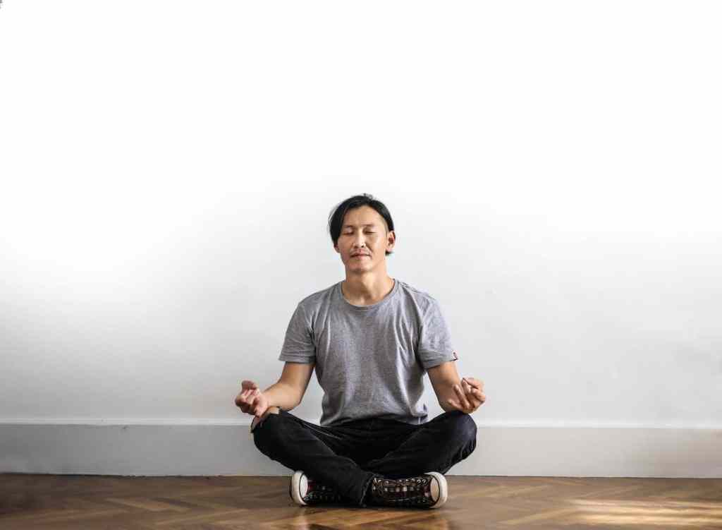 Young Asian man meditating in seated position daily routine