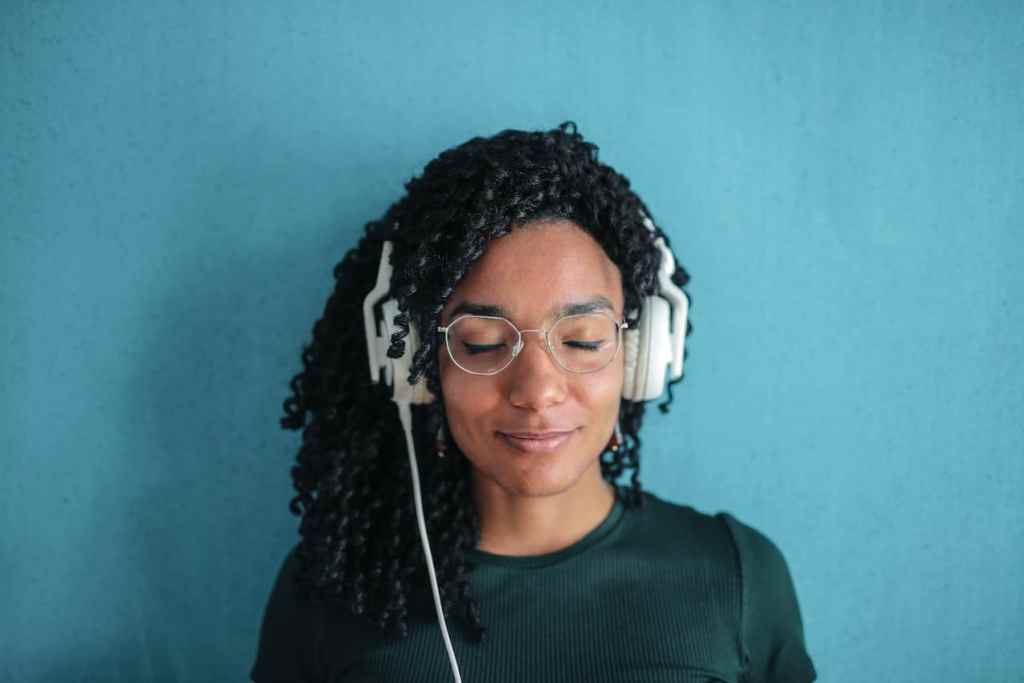 young black woman listening to meditation app on headphones