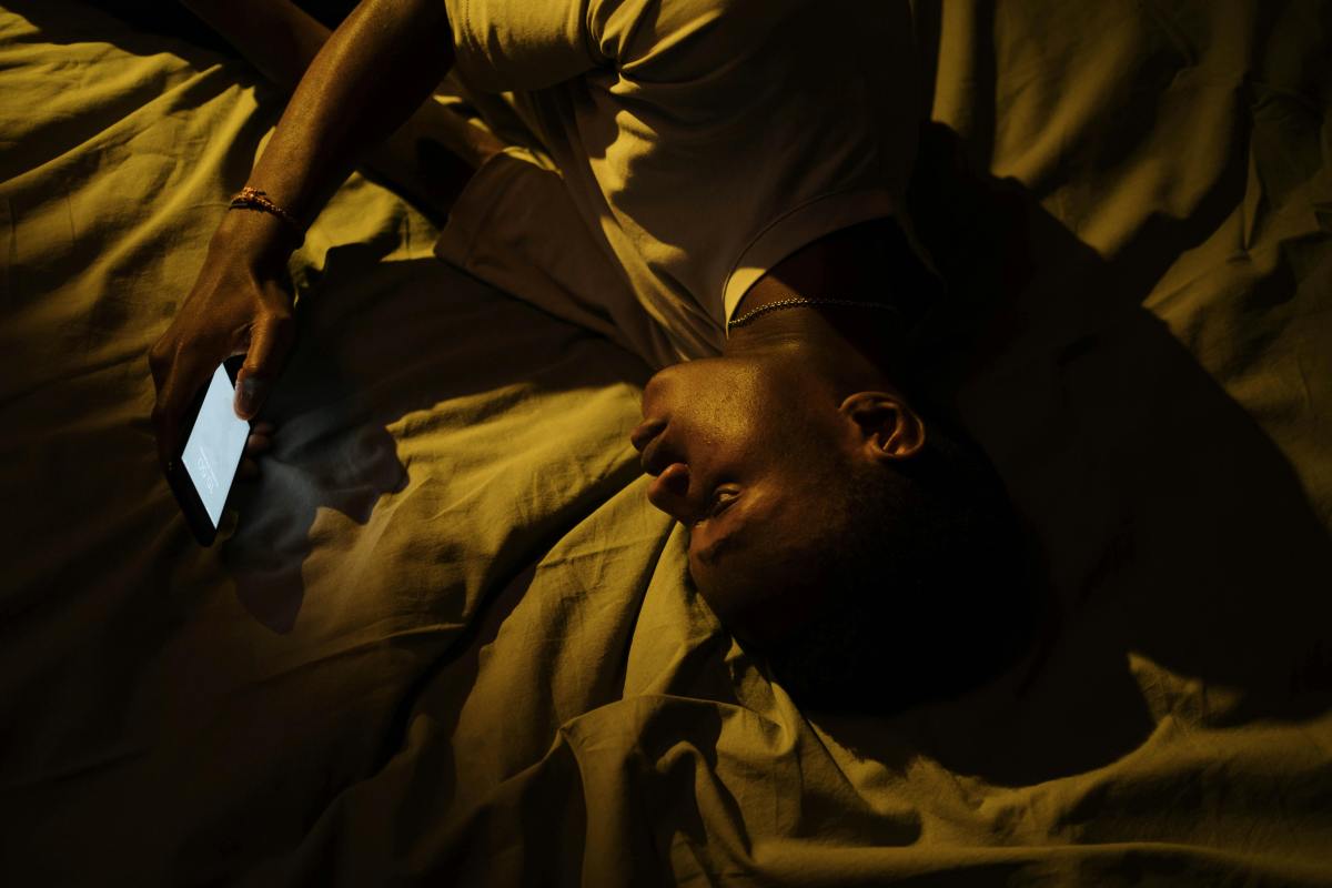 Man overstimulated by phone late at night, illustrating digital fatigue